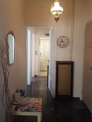 a hallway with a table and a clock on the wall at Superb Athenian Nest in Athens