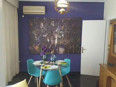 a dining room with a table and blue chairs at Superb Athenian Nest in Athens