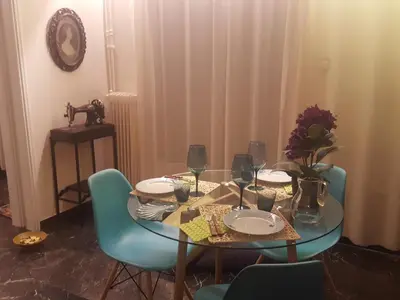 a dining room table with plates and wine glasses at Superb Athenian Nest in Athens