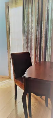 a wooden table and a chair in front of a curtain at Olympic Fashion Hotels in Athens
