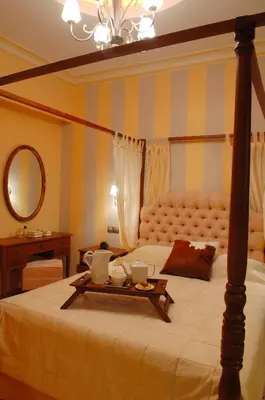 a bedroom with a bed with a tray of food on it at Olympic Fashion Hotels in Athens