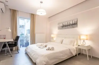a bedroom with a white bed with two towels on it at Stadium 1bdr HiEnd quiet Flat Top Location in Athens