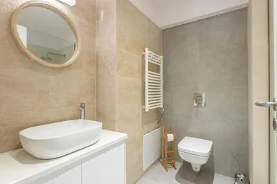 a bathroom with a sink and a toilet and a mirror at Stadium 1bdr HiEnd quiet Flat Top Location in Athens