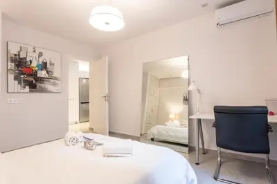 a bedroom with a bed and a mirror and a chair at Stadium 1bdr HiEnd quiet Flat Top Location in Athens