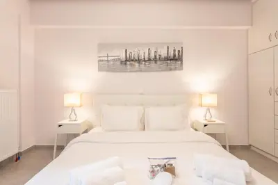 a bedroom with a large white bed with two lamps at Stadium 1bdr HiEnd quiet Flat Top Location in Athens
