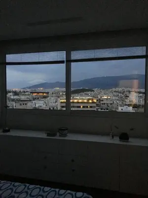 a room with two windows with a view of a city at Mind-blowing Acropolis View Apt in Athens