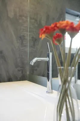 a bathroom sink with a faucet and a vase of flowers at Mind-blowing Acropolis View Apt in Athens
