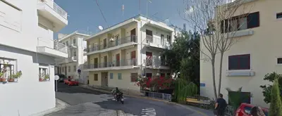 a man riding a motorcycle down a street next to a building at Mind-blowing Acropolis View Apt in Athens
