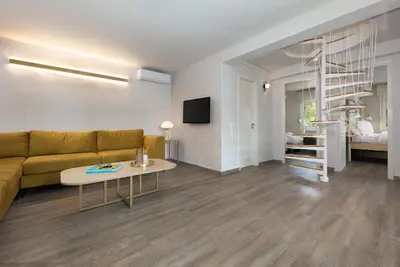a living room with a couch and a table at Vouliagmeni Stylish Homes by BluPine in Athens