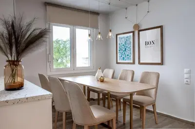 a dining room with a wooden table and chairs at Vouliagmeni Stylish Homes by BluPine in Athens
