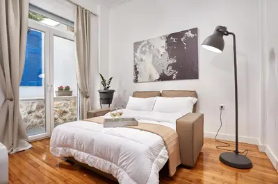 a bedroom with a bed and a lamp and a window at Luxury apartment central in Athens