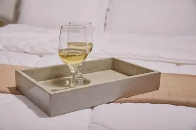 a glass of wine sitting in a tray on a bed at Luxury apartment central in Athens