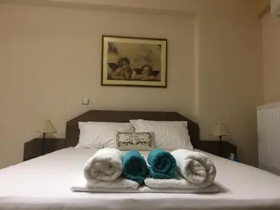 a bedroom with a bed with towels on it at Super 36sqm Junior Suite in luxurious picturesque area in Piraeus