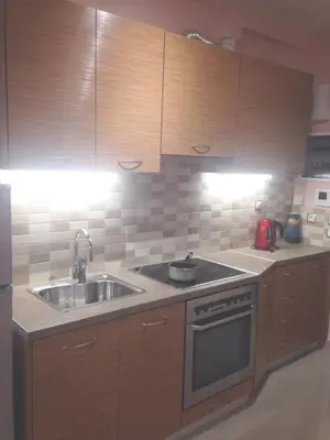 a kitchen with wooden cabinets and a sink at Super 36sqm Junior Suite in luxurious picturesque area in Piraeus