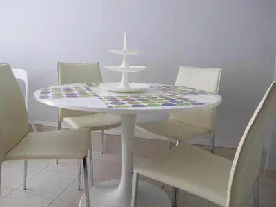 a white table with white chairs and a table with a patterned centerpiece at Athenian apartment with garden, near metro station Chalandri Nu 3 in Athens