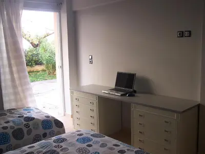 a bedroom with a desk with a laptop on it at Athenian apartment with garden, near metro station Chalandri Nu 3 in Athens