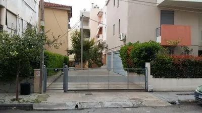 a gate leading to a driveway in a building at Athenian apartment with garden, near metro station Chalandri Nu 3 in Athens