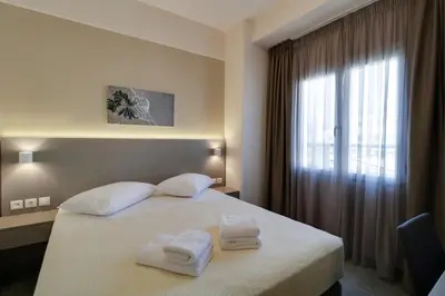 a hotel room with a bed with towels on it at Athens Comfort in Athens