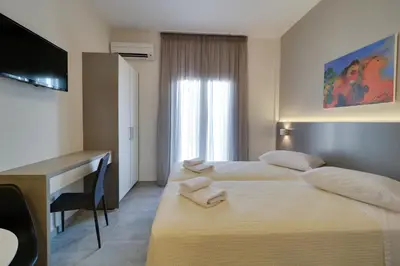 a hotel room with two beds and a desk and a computer at Athens Comfort in Athens