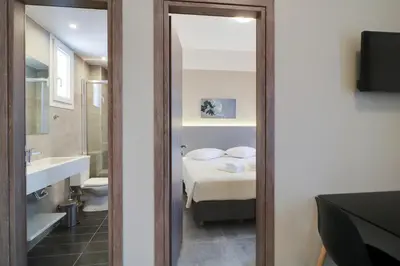a bathroom with a toilet and a sink and a mirror at Athens Comfort in Athens