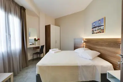 a hotel room with a bed and a desk at Athens Comfort in Athens