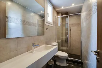 a bathroom with a toilet and a sink and a shower at Athens Comfort in Athens