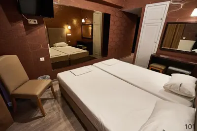 a bedroom with a large white bed and a mirror at Atlantic Hotel in Athens
