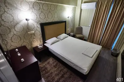 a hotel room with a bed and two night stands at Atlantic Hotel in Athens