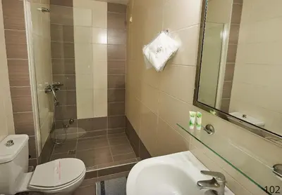 a bathroom with a toilet and a sink and a shower at Atlantic Hotel in Athens