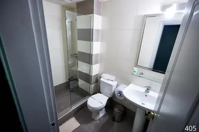 a bathroom with a toilet and a sink and a shower at Atlantic Hotel in Athens
