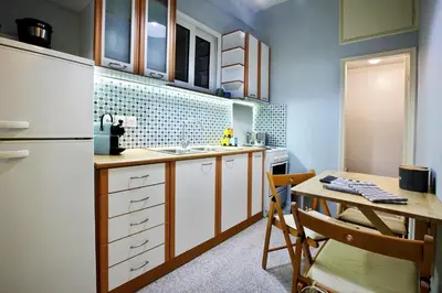 a kitchen with a table and a refrigerator at Athens Centre Apartment in Athens