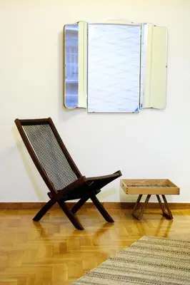 a rocking chair in a room with a mirror at Athens Centre Apartment in Athens