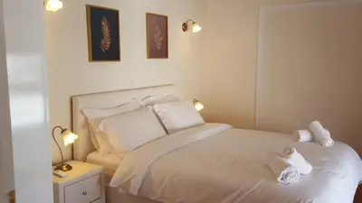 a bedroom with a bed with white sheets and pillows at Alexander's Penthouse in Athens