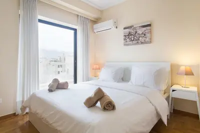 a bedroom with a large white bed with towels on it at Alexander's Penthouse in Athens