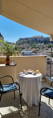 a table and chairs on a balcony with a view at Safestay Athens Monastiraki in Athens
