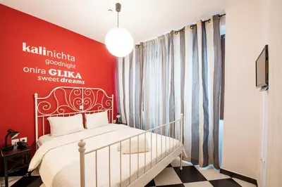 a bedroom with a white bed and a red wall at Safestay Athens Monastiraki in Athens