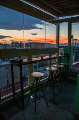 a bar with stools on a balcony with a view at Safestay Athens Monastiraki in Athens