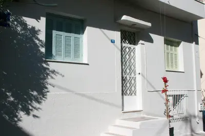 a white house with a door and a window at Sun sto Spiti in Athens