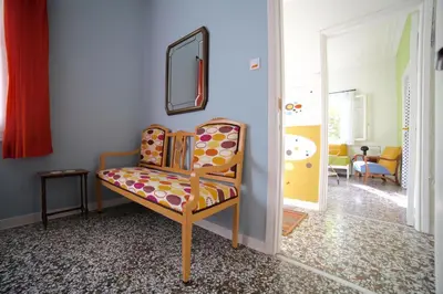 a chair in a living room with a mirror at Sun sto Spiti in Athens