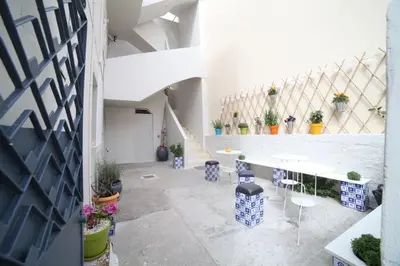 a room with tables and chairs and potted plants at Sun sto Spiti in Athens