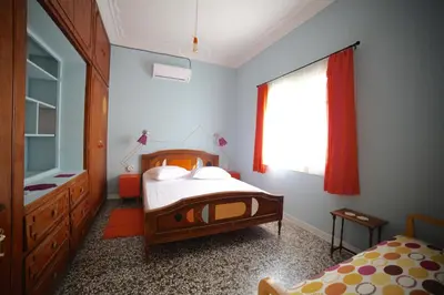 a bedroom with a bed and a dresser and a window at Sun sto Spiti in Athens