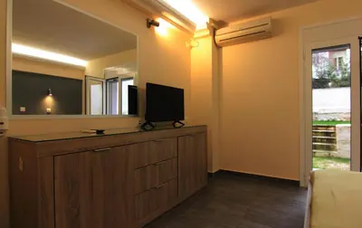 a living room with a tv and a mirror at Ariston Hotel in Athens