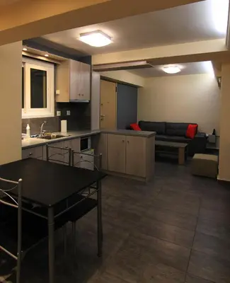a kitchen and living room with a table and a couch at Ariston Hotel in Athens