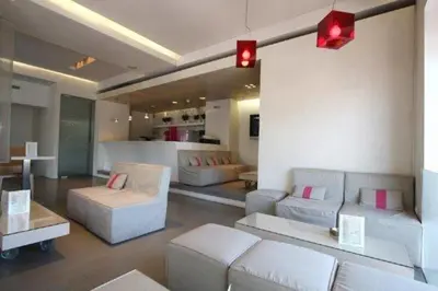 a living room with white couches and pink pillows at Ariston Hotel in Athens