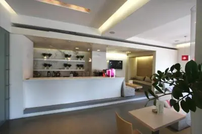 a lobby with a waiting area with a table and chairs at Ariston Hotel in Athens