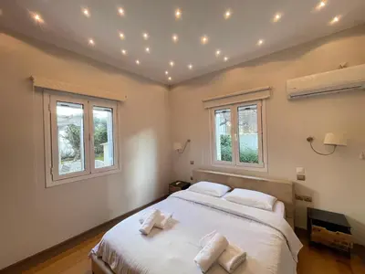 a bedroom with a large white bed with three pillows at Aquarius - Glyfada detached house in Athens