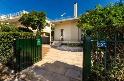 a green gate in front of a house at Aquarius - Glyfada detached house in Athens