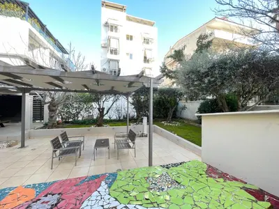 a patio with a table and chairs and an umbrella at Aquarius - Glyfada detached house in Athens