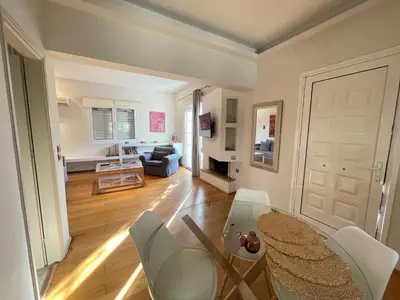 a living room with a glass table and white chairs at Aquarius - Glyfada detached house in Athens
