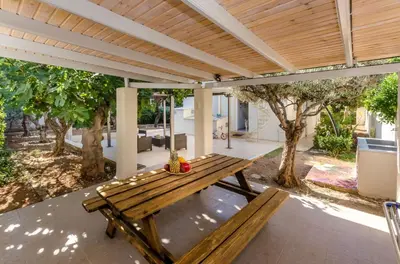 a wooden picnic table under a pergola at Aquarius - Glyfada detached house in Athens